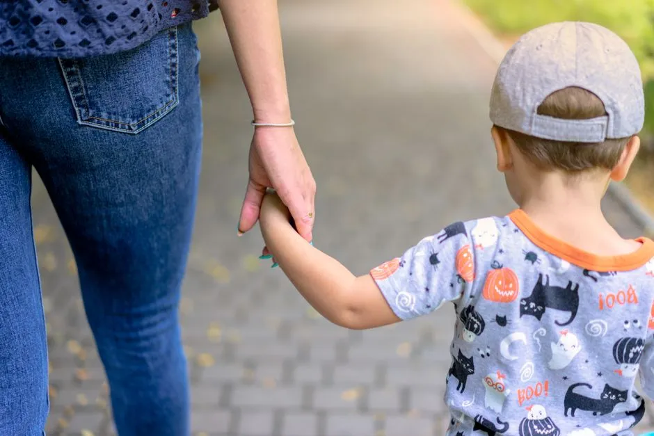 Parent et enfant marchant main dans la main : protection de l'enfance en Ardèche