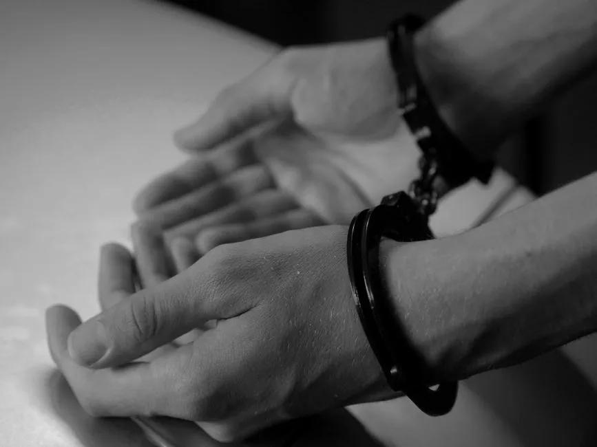 Personne menottée en garde à vue assistée par son avocat